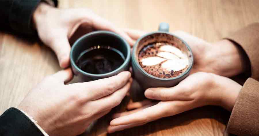  A photo of two hands holding coffee