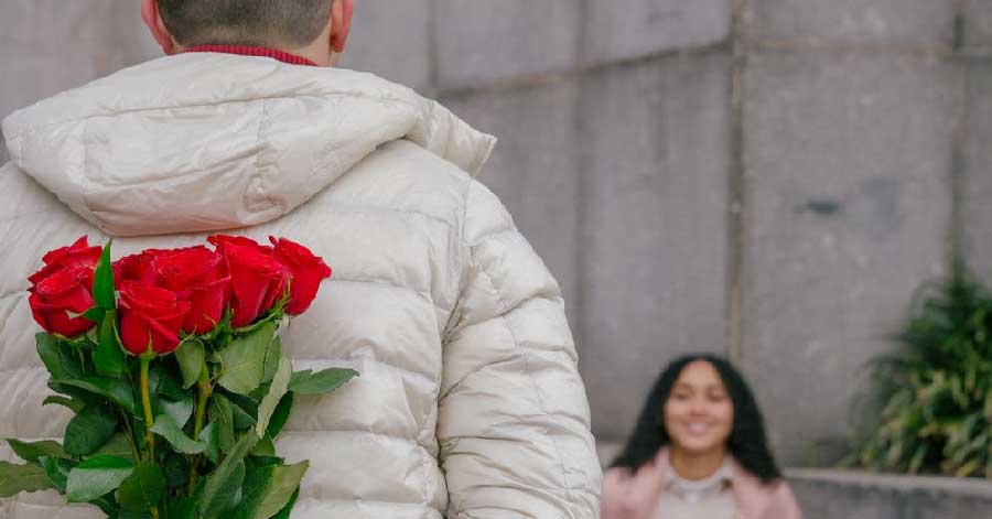  A man about to give a bunch of flowers to his date.